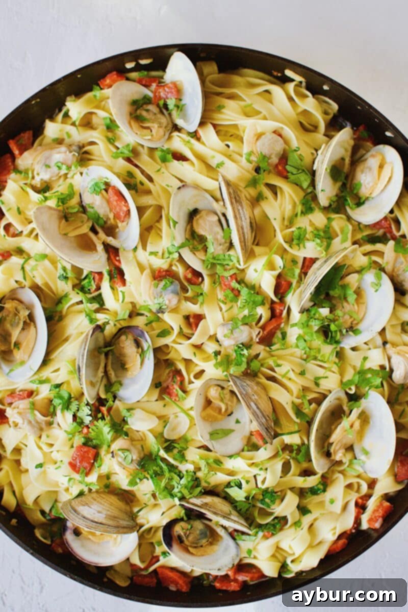 Linguine with Clams 14 A close-up of the finished Linguine with Clam Sauce, beautifully tossed and garnished, emphasizing the succulent clams, vibrant herbs, and glistening pasta strands.