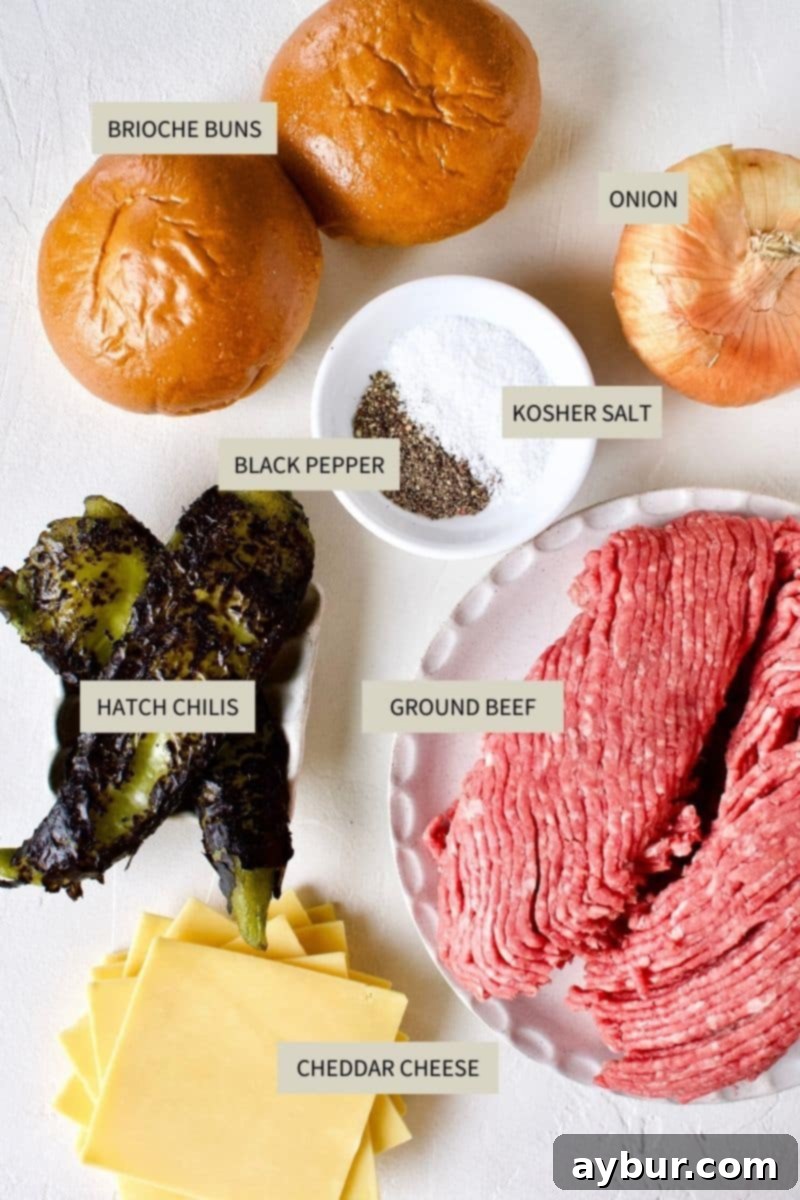 Ingredients needed to make Green Chili Cheeseburgers, including ground beef, hatch chiles, onion, cheese, and brioche buns.