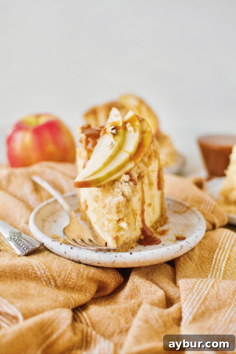 Caramel Apple Crisp Cheesecake, beautifully topped with caramel sauce and thinly sliced fresh apples, ready to be served.