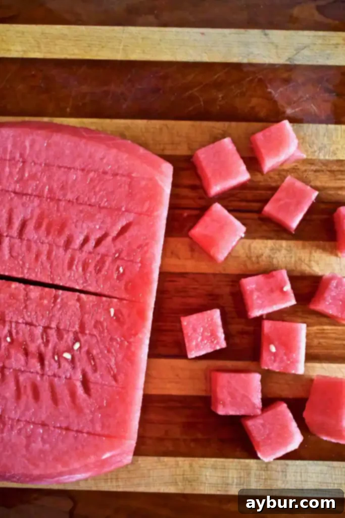 Unlock the Art of Watermelon Slicing 8 Watermelon being cut into sticks and then diced into cubes.