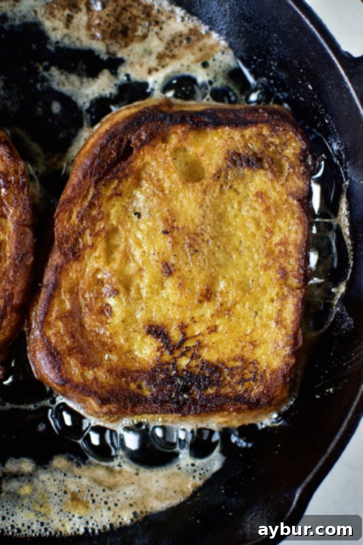 The first side of the pumpkin French toast, beautifully golden brown after its initial flip.