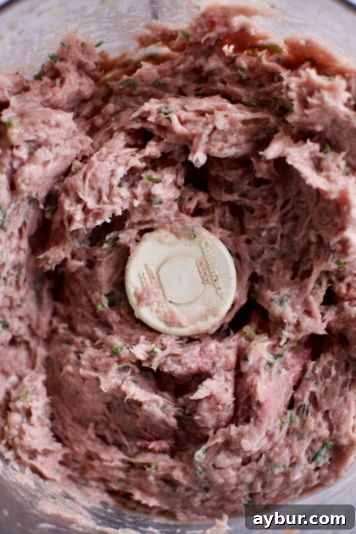 The ground meat mixture, perfectly blended with spices, onion, and egg in a food processor, ready for shaping.