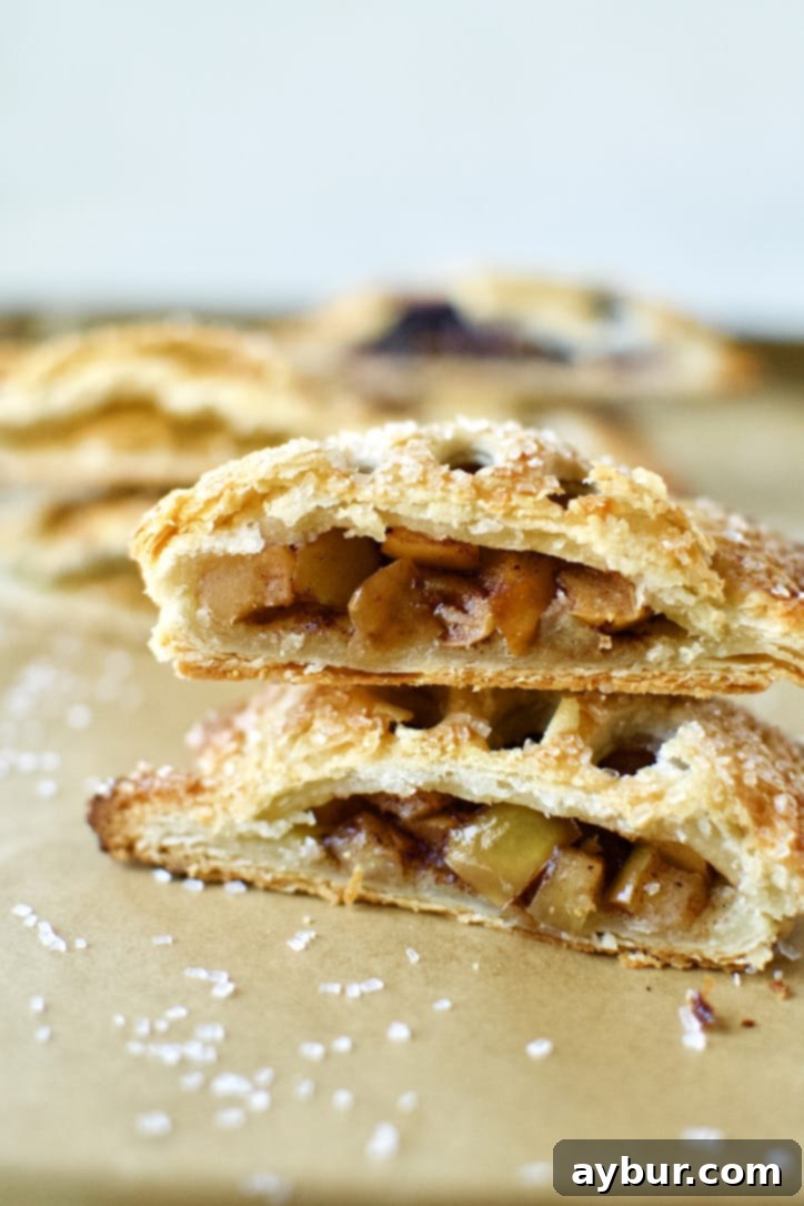 A beautifully baked Caramel Apple Hand Pie, sliced in half, revealing its rich filling.