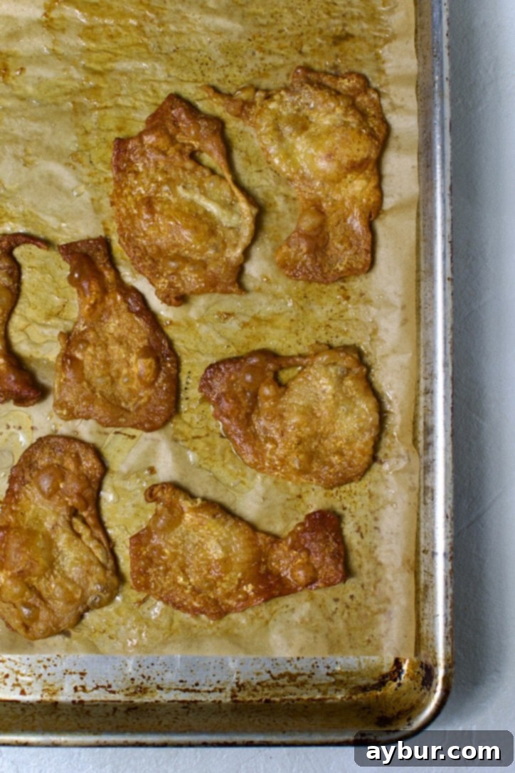 Rendered chicken skins and fat on a baking sheet.
