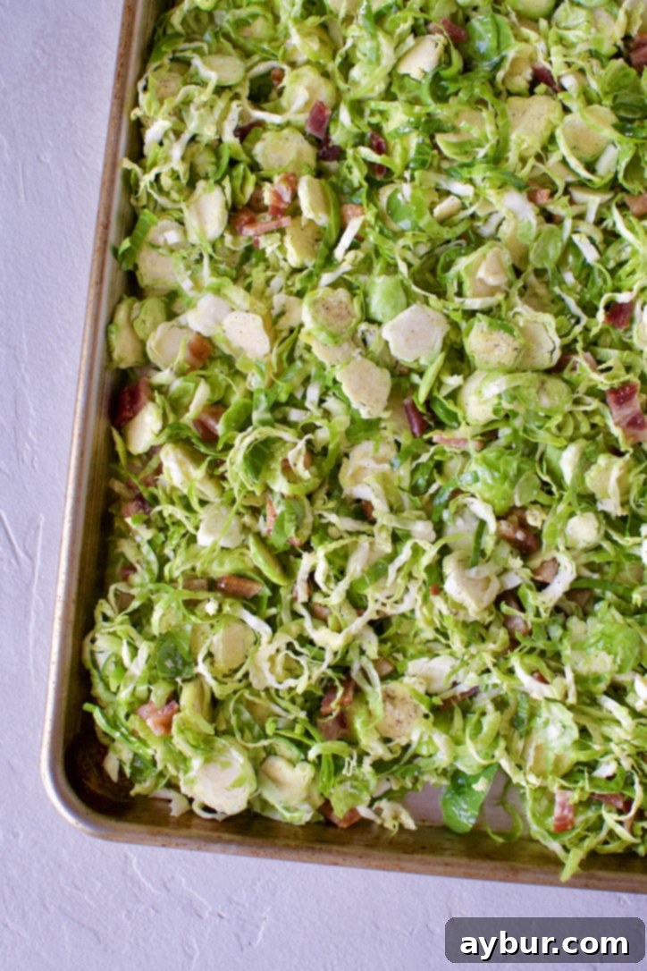 Brussels sprouts roasting in the oven, partially crisped.