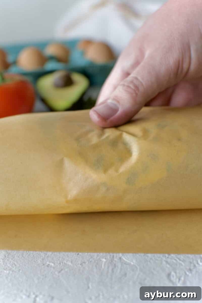 Wholesome Breakfast Sandwich 20 Securing the wrapped breakfast sandwich with tape.