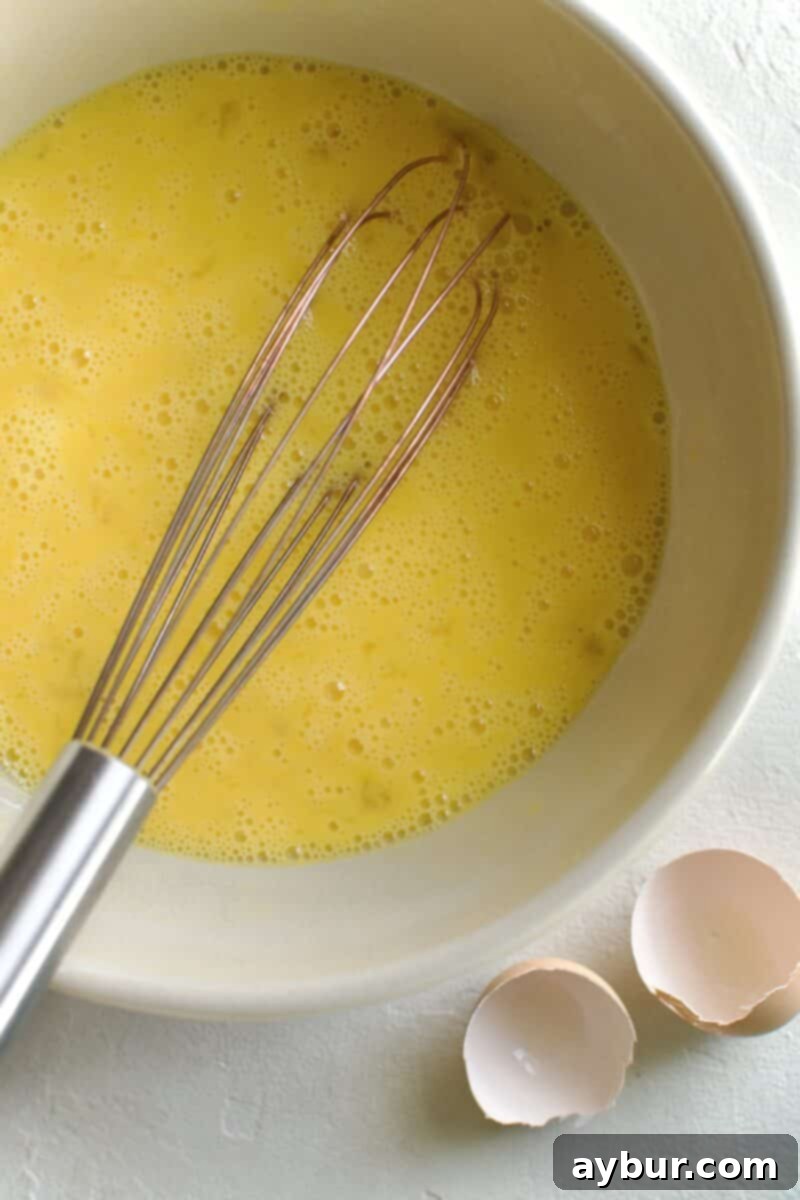 Wholesome Breakfast Sandwich 5 Adding half-and-half to the whisked eggs.