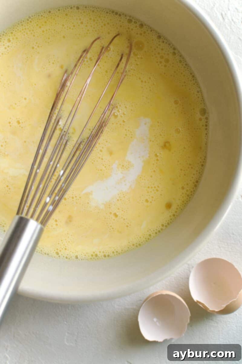 Wholesome Breakfast Sandwich 6 Adding olive oil to the egg mixture.