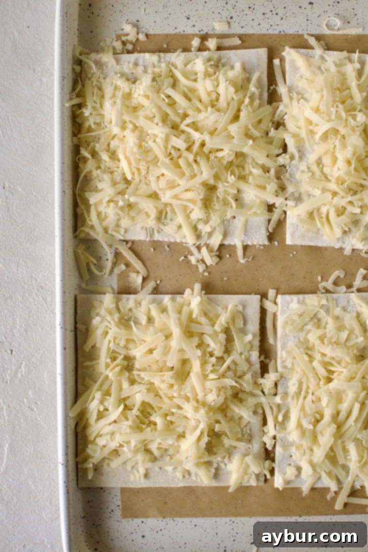 Beef Pot Pie 11 Irish Cheddar Puff Pastry Squares, generously topped with cheese, awaiting their transformation in the oven.