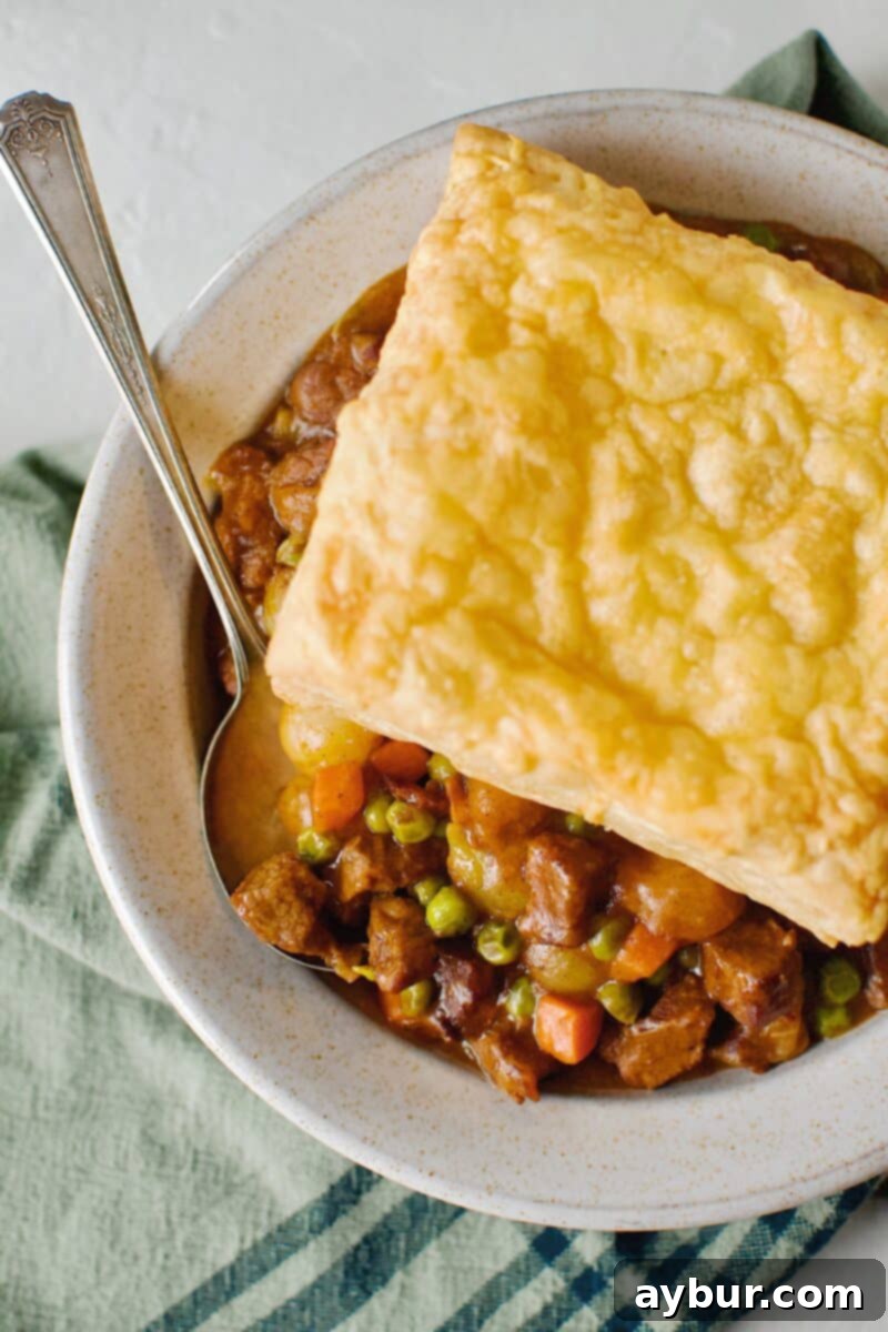 Beef Pot Pie 13 A perfectly assembled Beef Pot Pie, crowned with a golden Irish Cheddar Puff Pastry Square, steaming and ready to be enjoyed.