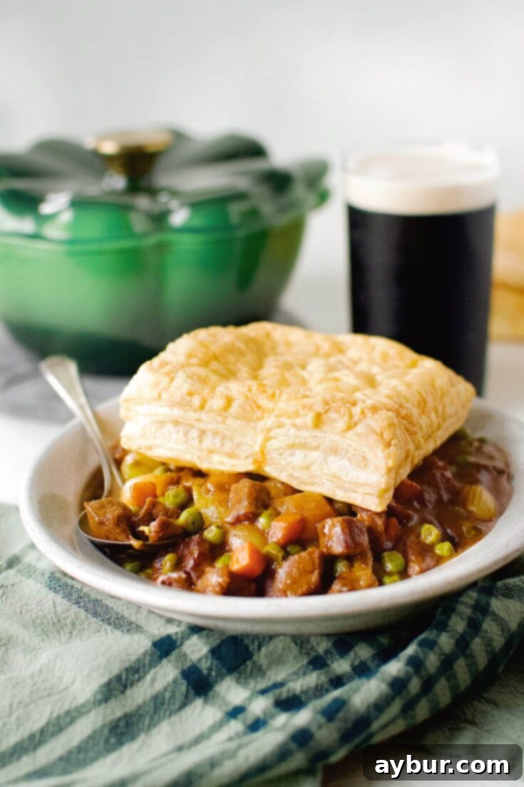 Beef Pot Pie 15 Beef Pot Pie topped with an Irish Cheddar Puff Pastry Square, ready to eat with a Guinness in the background.