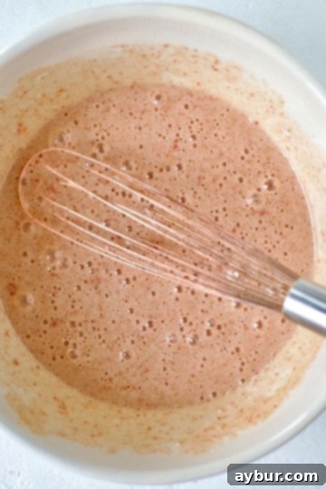 Whisking together the sugar and eggs for ruby chocolate brownies, aiming for a fudgy texture.