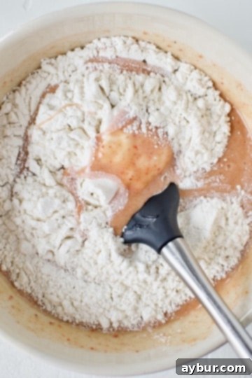 Gently folding in the flour to the ruby chocolate brownie batter to achieve the perfect consistency.