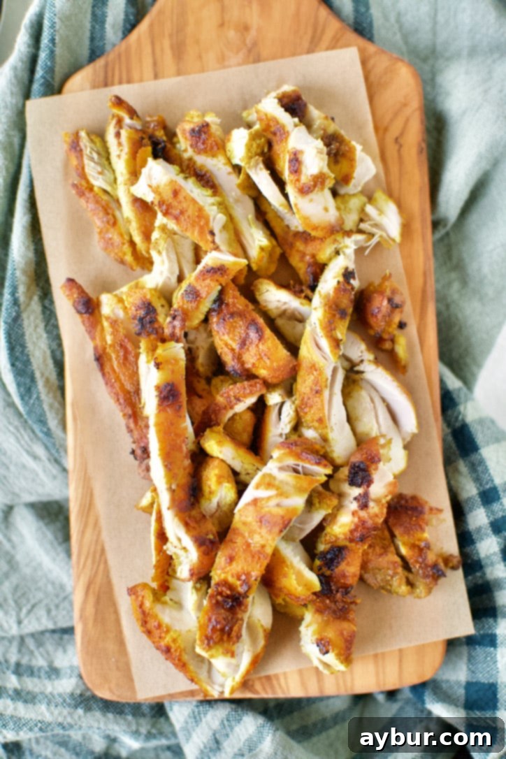 Perfectly cooked and sliced Chicken Shawarma arranged on a wooden cutting board, ready for serving.