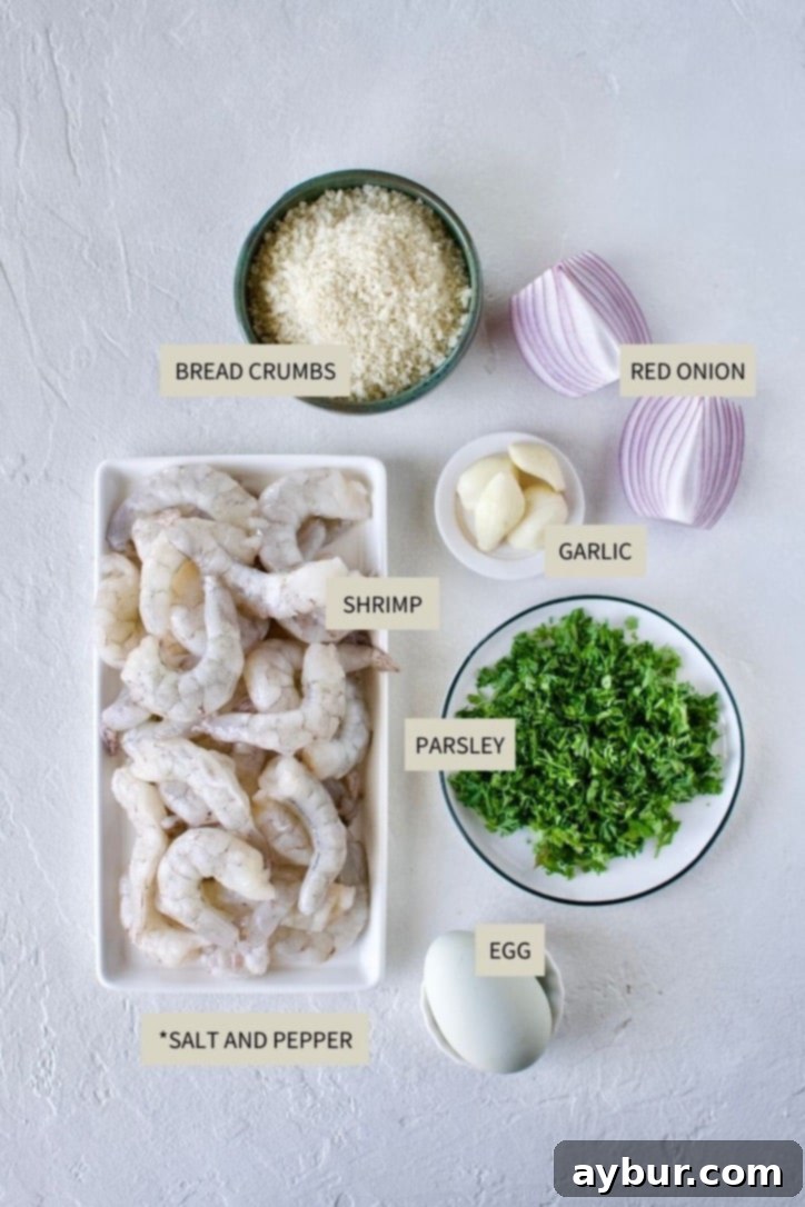 Fresh ingredients laid out for making Shrimp Balls: red onion, garlic, parsley, raw shrimp, panko breadcrumbs, and an egg.