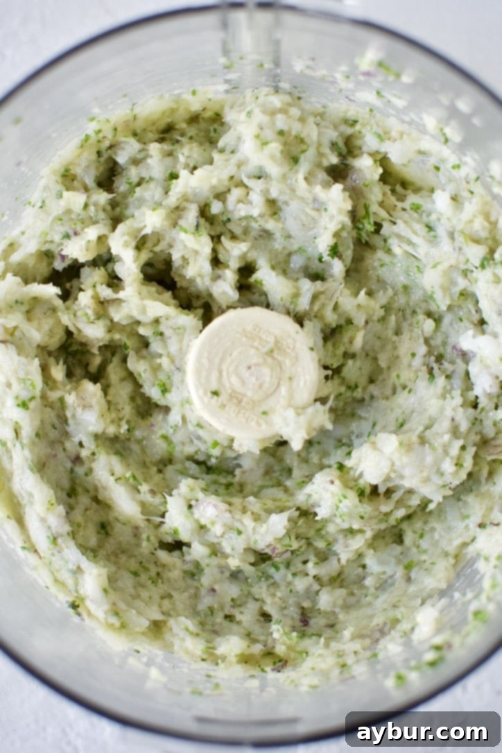 Blended parsley, garlic, and red onion in a food processor with added shrimp, bread crumbs, and egg yolk, pulsed together until well combined but still textured.