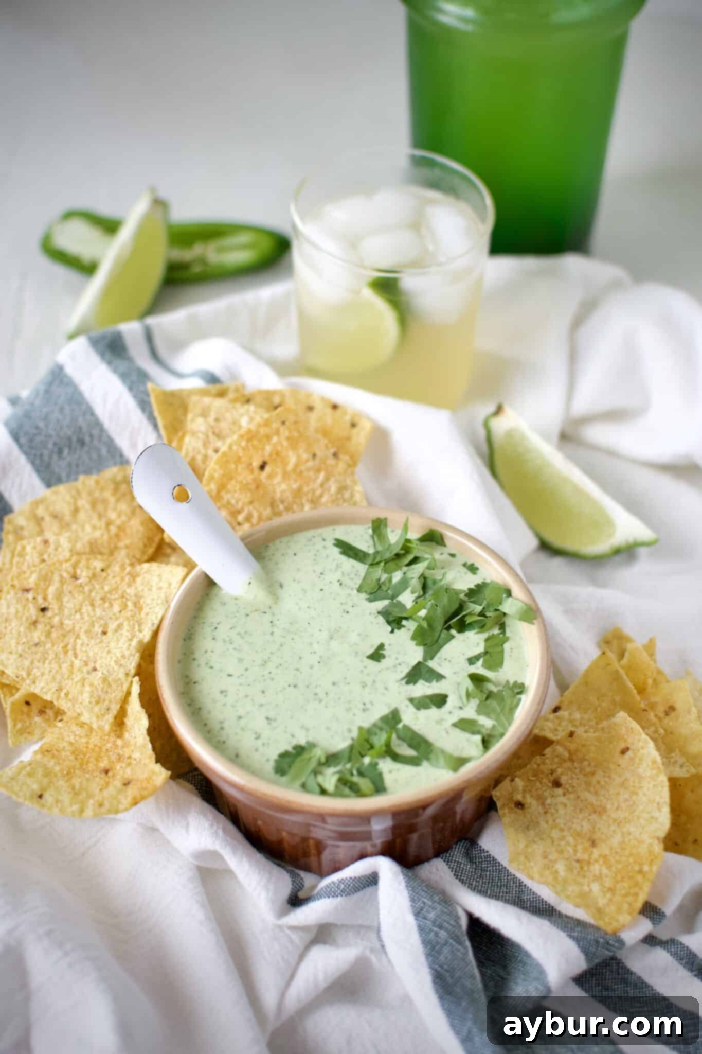 Creamy Jalapeño Dip served with chips and alongside a fresh margarita.