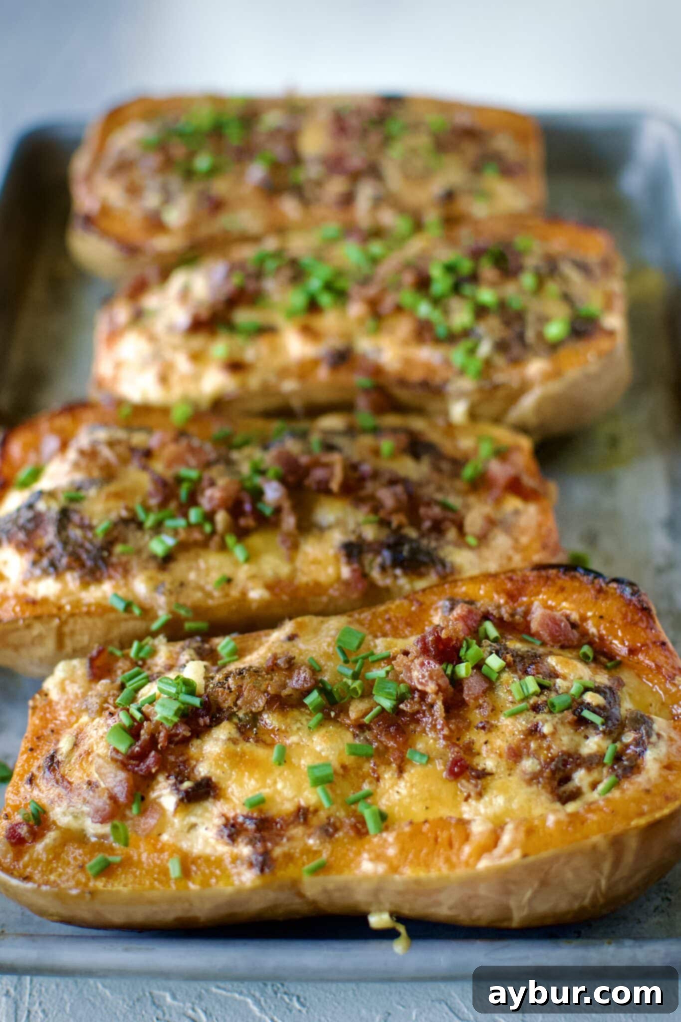 Jalapeño Popper Butternut Squash Boats 9 Two halves of Stuffed Butternut Squash, cooked and ready to be served, garnished with fresh herbs.