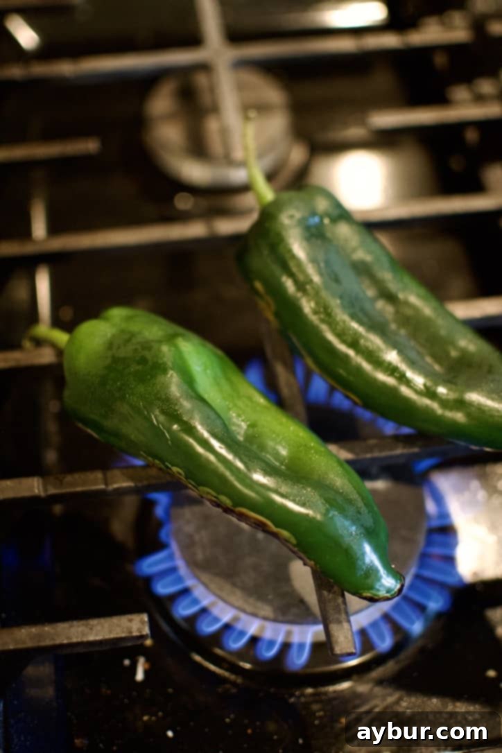 Smoky Sweet Corn and Pepper Salsa 4 Blistering poblano peppers directly over a gas stove flame, showing the skin turning black and bubbling.