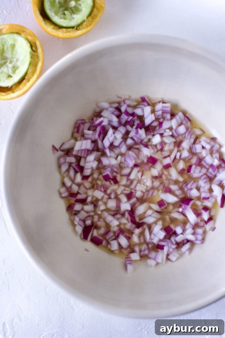 Smoky Sweet Corn and Pepper Salsa 8 Small diced red onions in a bowl, glistening with lime and orange juices, ready to be mixed with other salsa ingredients.
