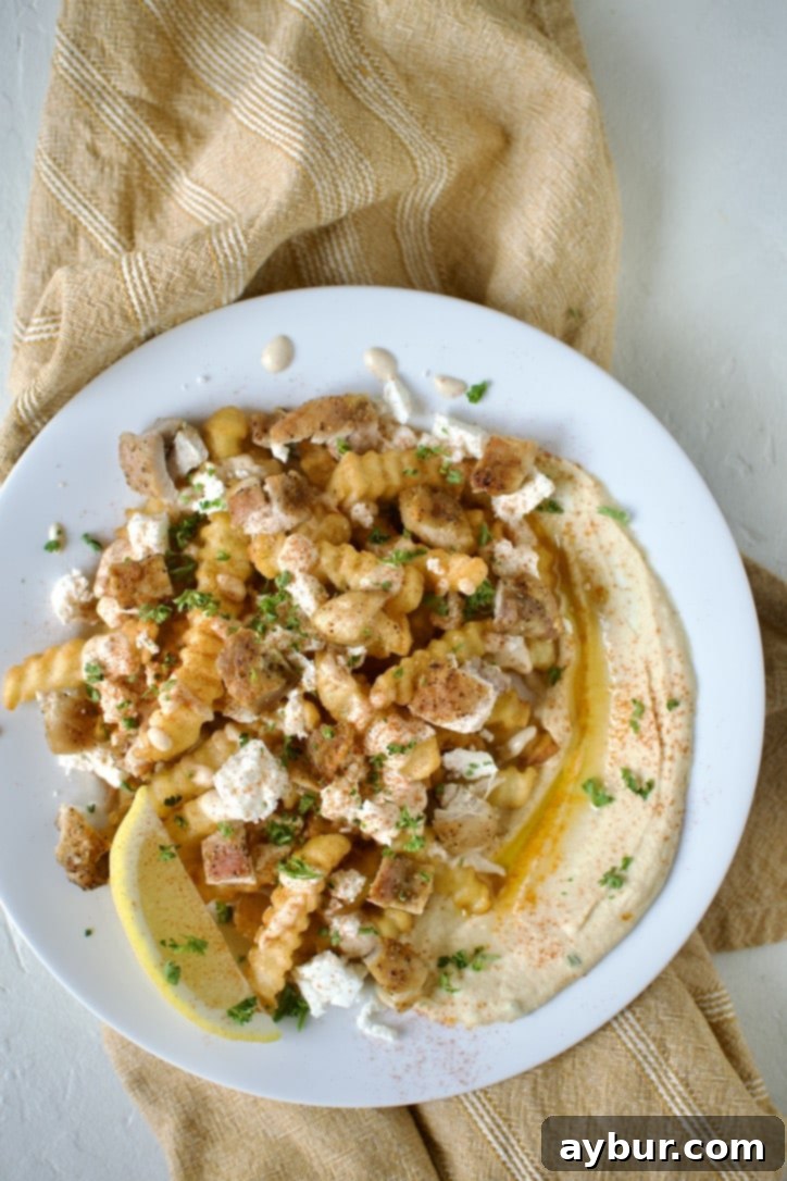 Loaded Greek Chicken Fries 11 Assembling a plate of Greek Fries. Step 6, finishing with a dusting of paprika and parsley.