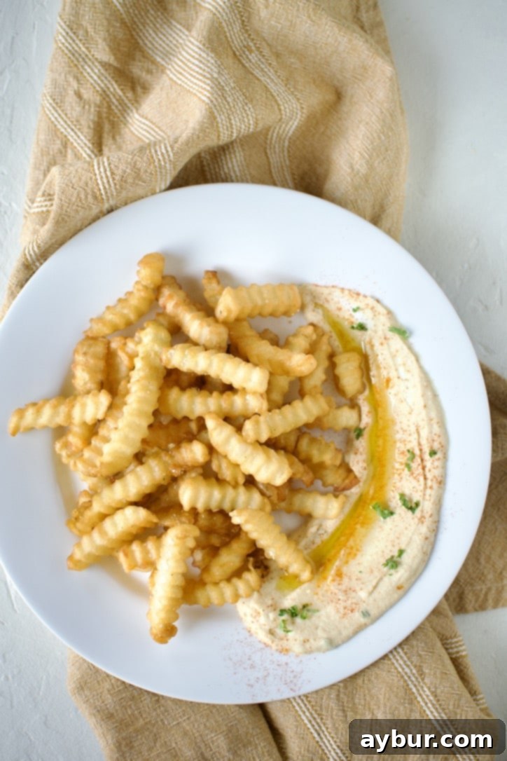 Loaded Greek Chicken Fries 7 Assembling a plate of Greek Fries. Step 2, adding fresh fries to the plate.