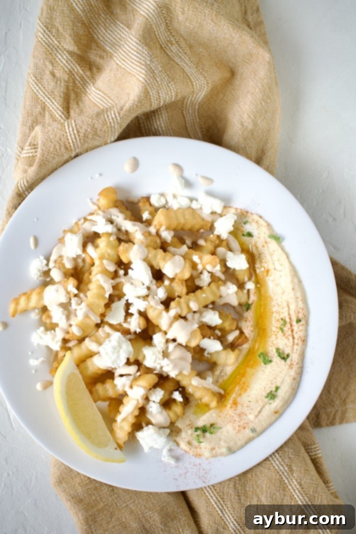 Loaded Greek Chicken Fries 9 Assembling a plate of Greek Fries. Step 4, topping with feta cheese..