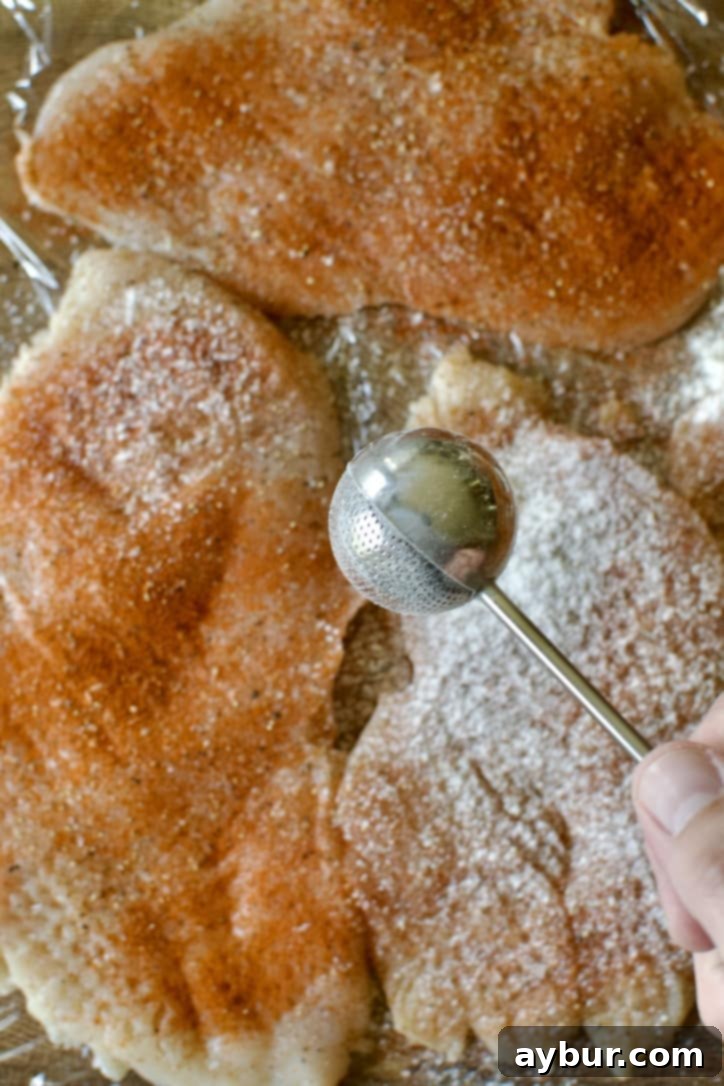 Chip-Crusted Chicken 5 seasoning chicken breasts with salt, pepper, paprika, and flour.