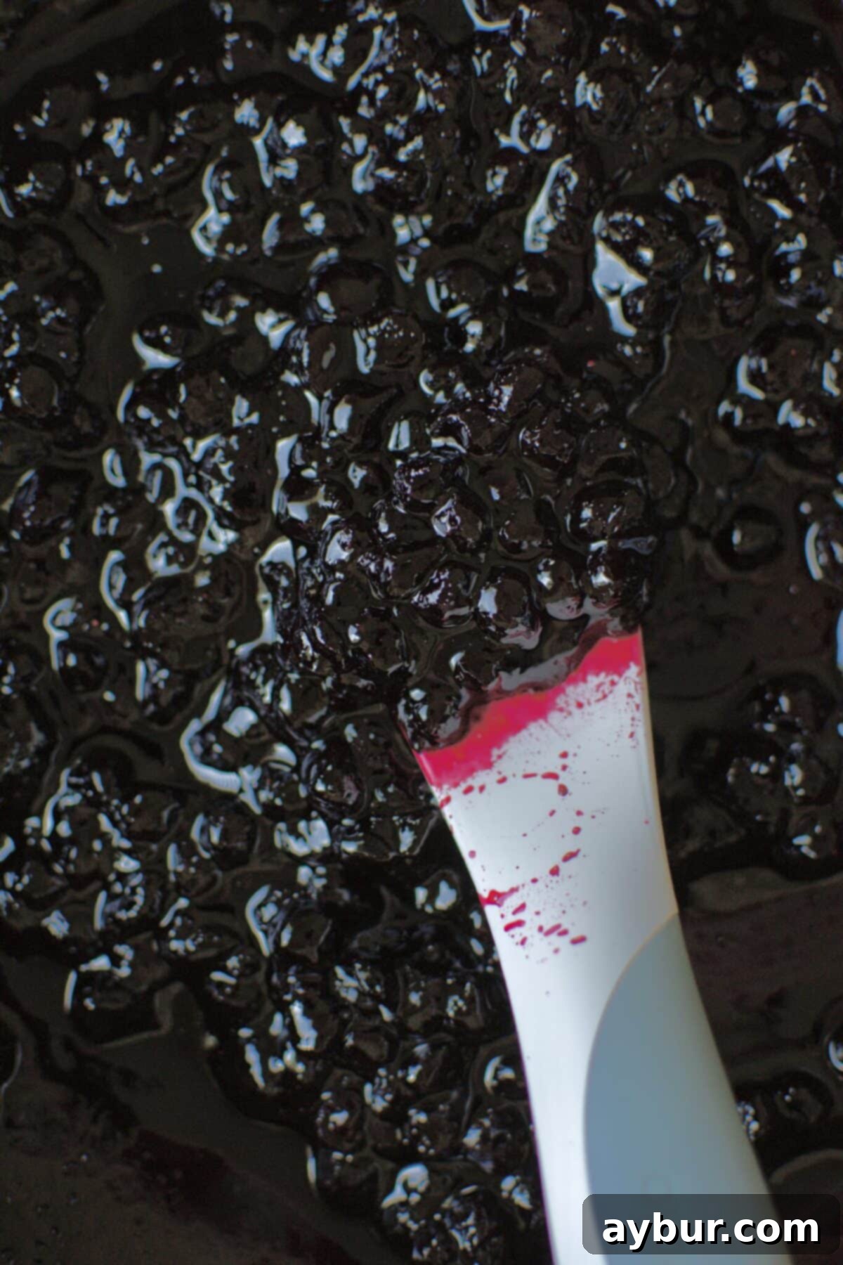 Effortless Tres Leches Cake 12 A skillet filled with vibrant, cooked homemade blueberry jam, cooling down.