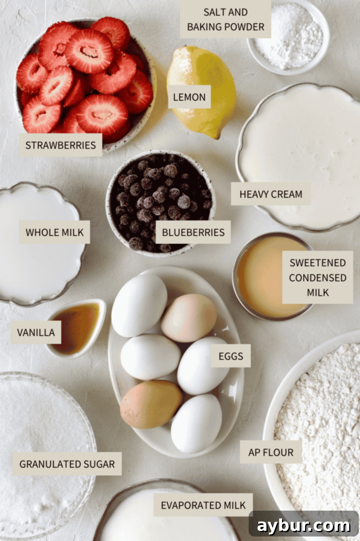 Effortless Tres Leches Cake 3 Assortment of fresh ingredients laid out, including eggs, flour, milk, and blueberries, essential for making Easy Tres Leches Cake.