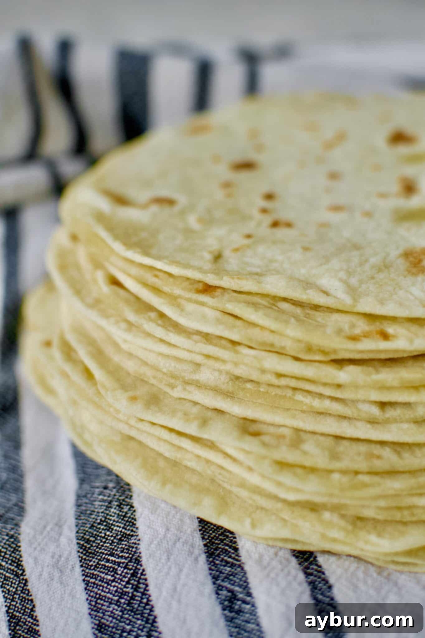 Stack of warm, freshly cooked homemade flour tortillas, ready to serve and enjoy.