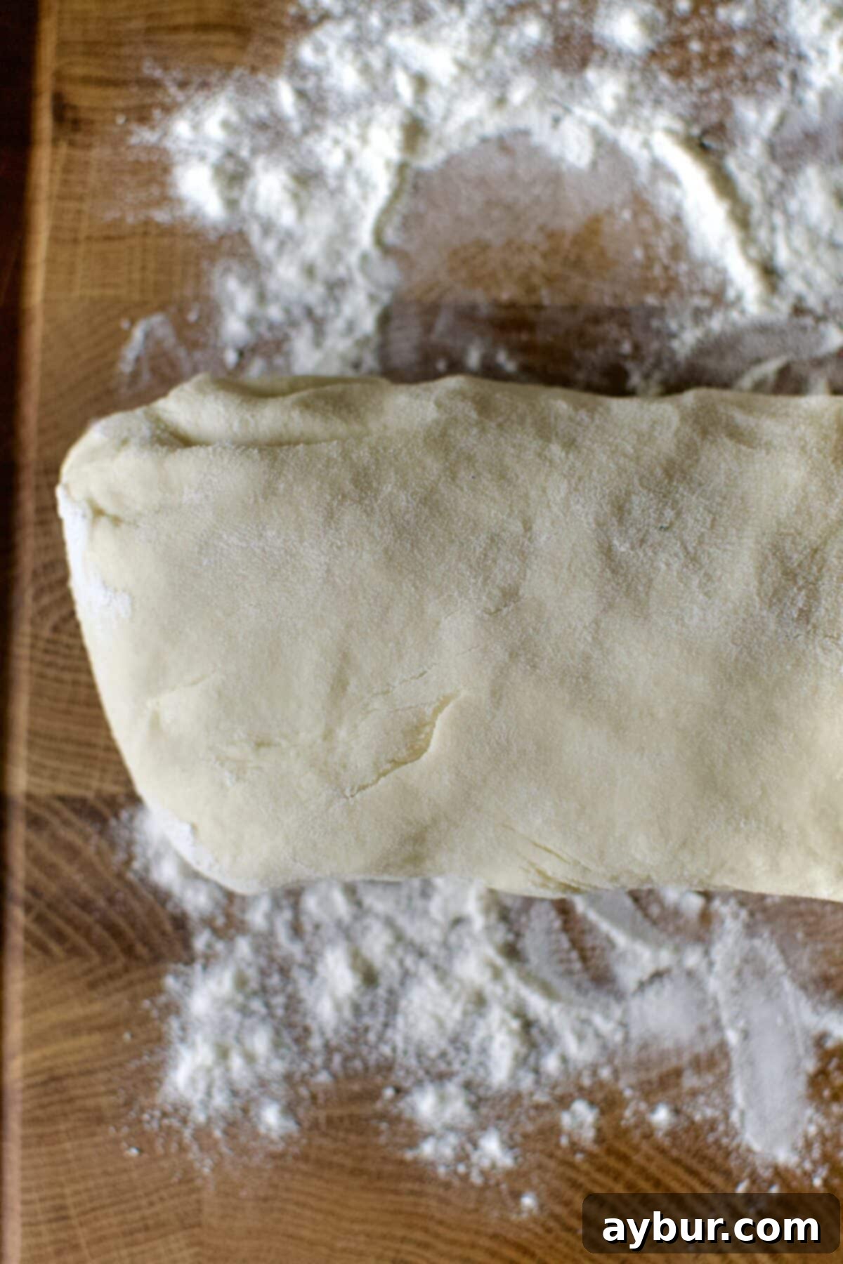 Tortilla dough rolled out into an even log shape, ready for precise portioning.