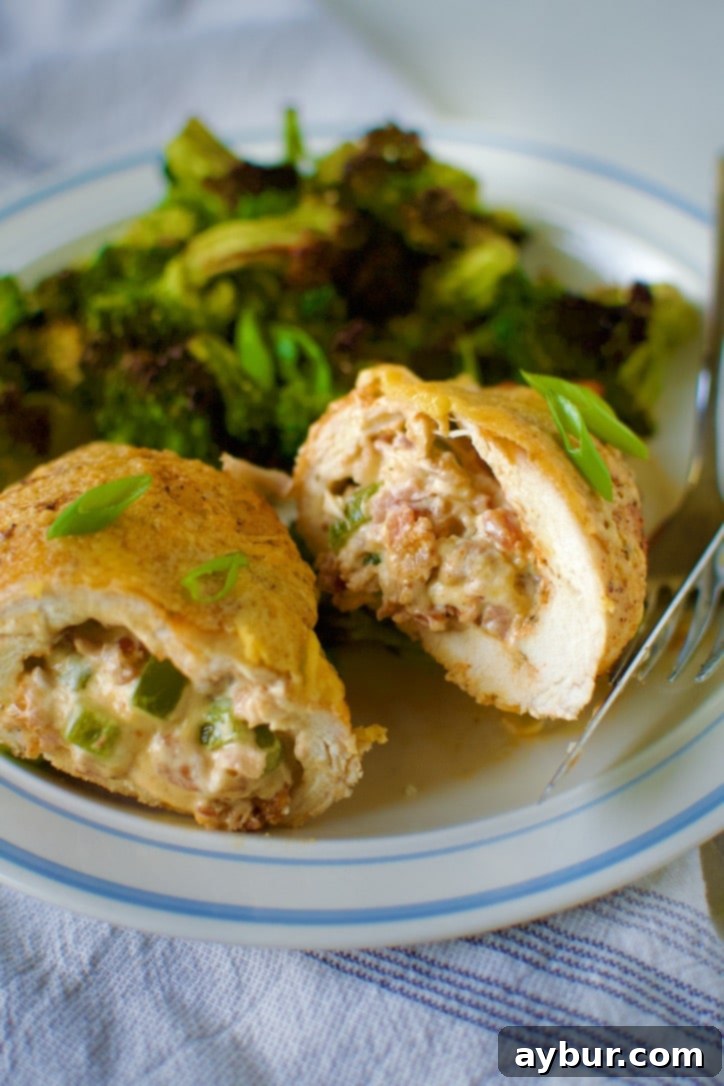 Jalapeño Popper Stuffed Chicken 16 Stuffed Chicken Breast with Cheese cut open on a plate with roasted broccoli ready to eat.