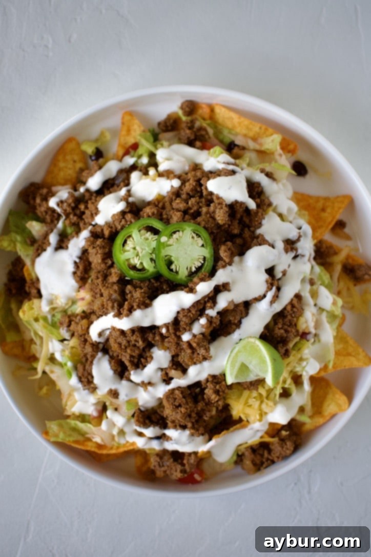 Garnishing the finished taco salad with fresh lime wedges for a burst of citrus flavor.