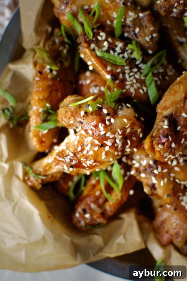 A serving of finished Teriyaki Chicken Wings garnished with green onions and sesame seeds, ready to be enjoyed.