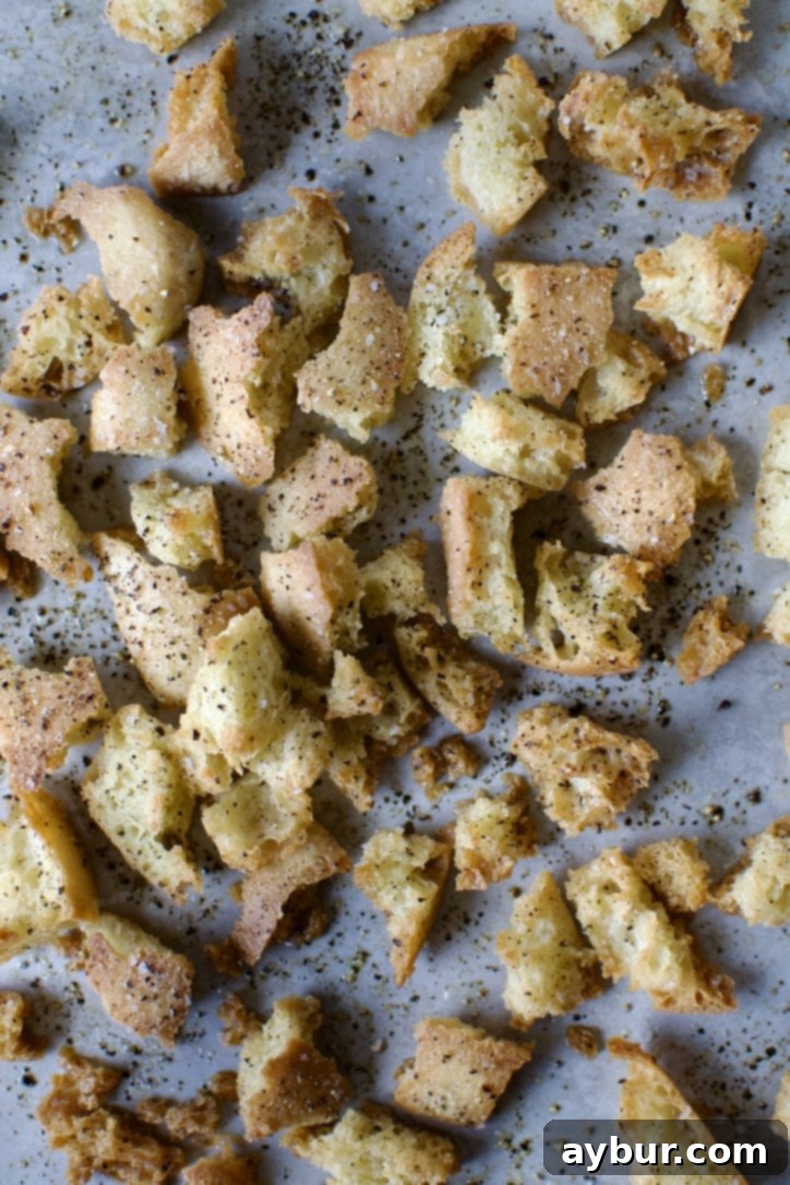 Traditional Caesar Salad 5 Seasoned bread pieces spread evenly on a baking sheet, prepped for making crispy homemade croutons.