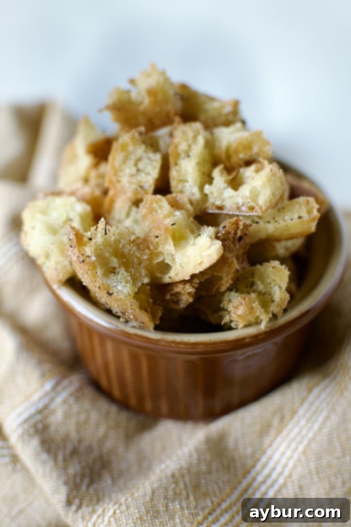 Traditional Caesar Salad 6 Golden brown, freshly baked homemade croutons cooling on a baking sheet, ready to be added to Caesar salad.