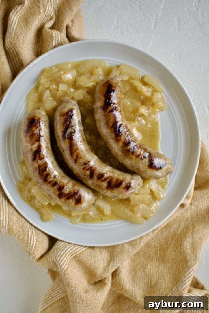 Braised and Grilled Brats served over braised and buttered onions.
