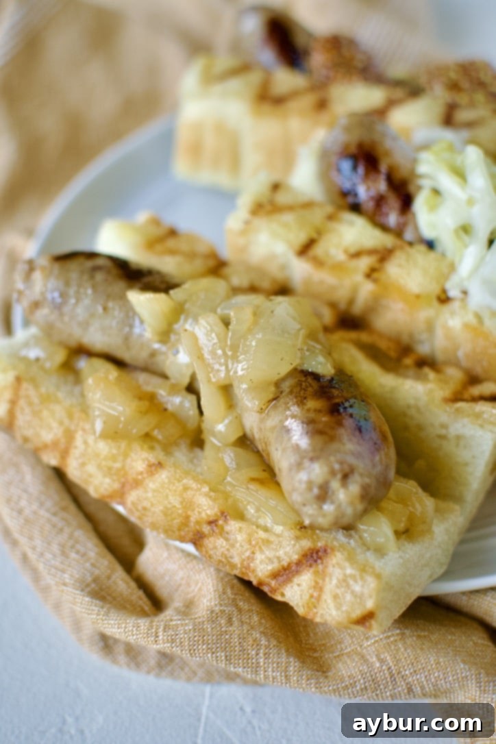 Braised and Grilled Brats served on grilled buns with onions on it.