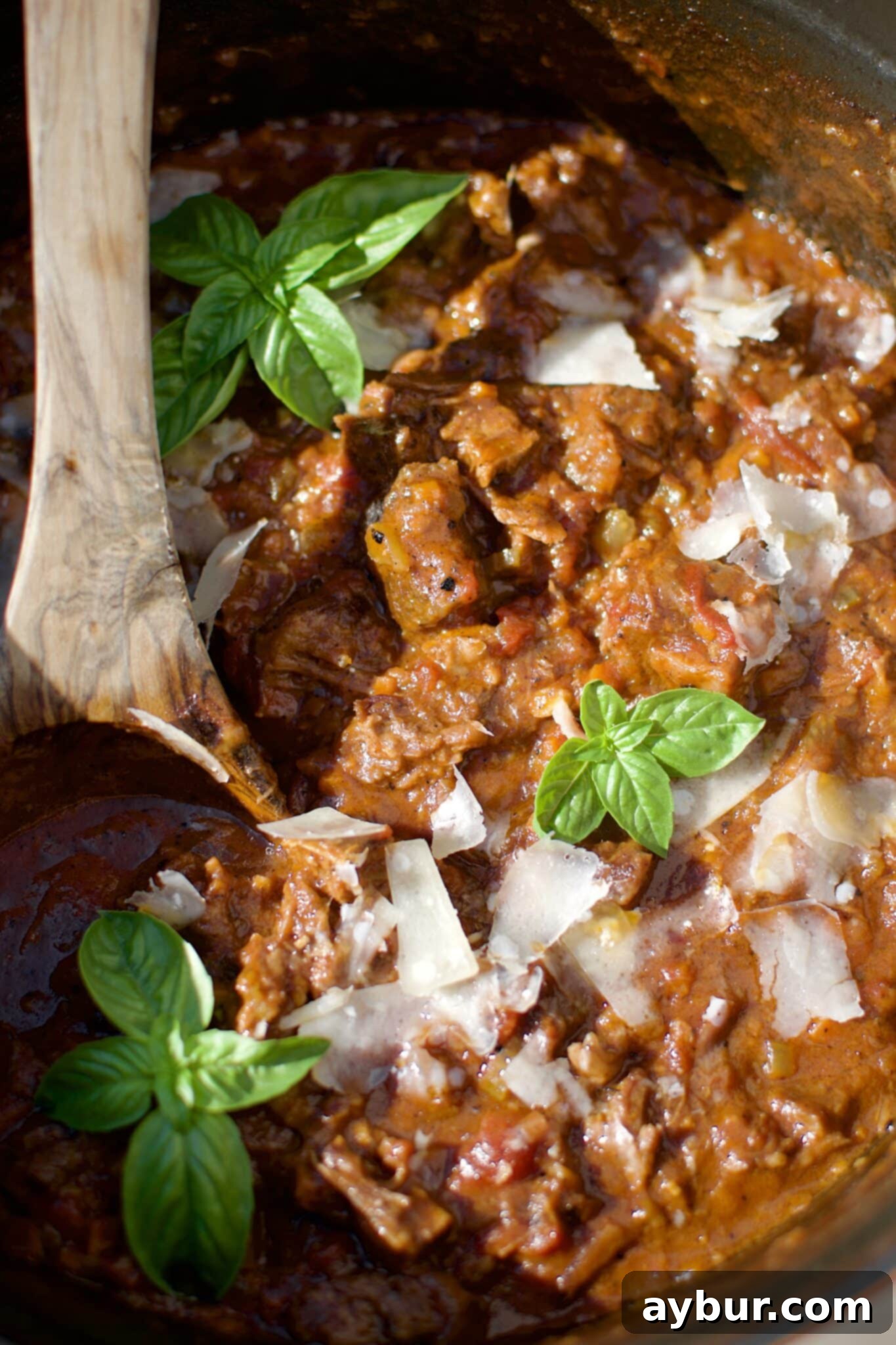 Finished Short Rib Bolognese sauce ready to be put on pasta or polenta, garnished with fresh basil.