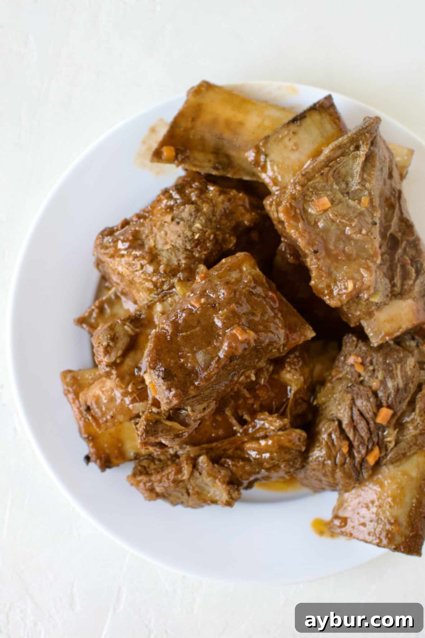 Intact short ribs carefully removed from the pot after braising.