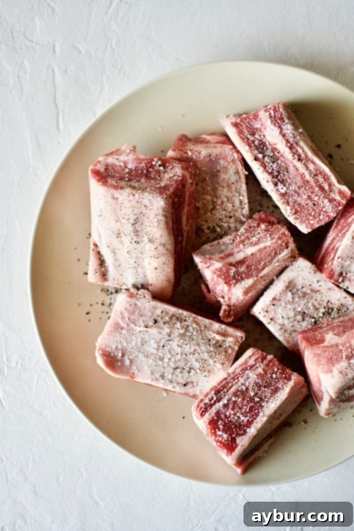 Short Ribs generously seasoned with salt and pepper, ready for searing.