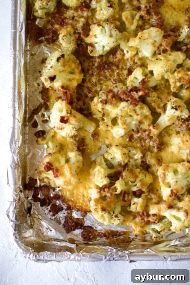 Broiled loaded cauliflower with melted and slightly crisped cheese and bacon.