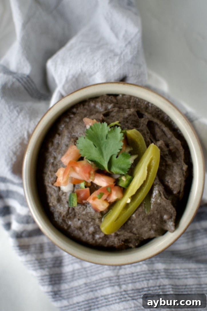 Easy Creamy Black Bean Dip 6 Black Bean Dip in a bowl, topped with pico de gallo, cilantro, and a slice of jalapeno.