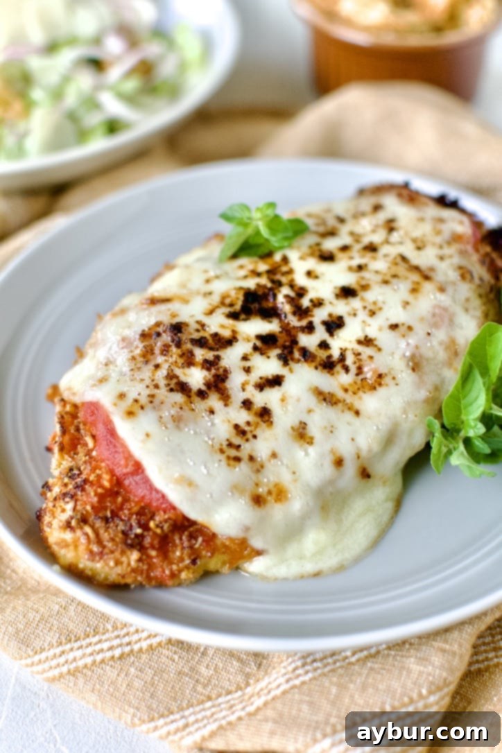 Easy Baked Chicken Parmesan served on a plate with pasta, ready to enjoy.