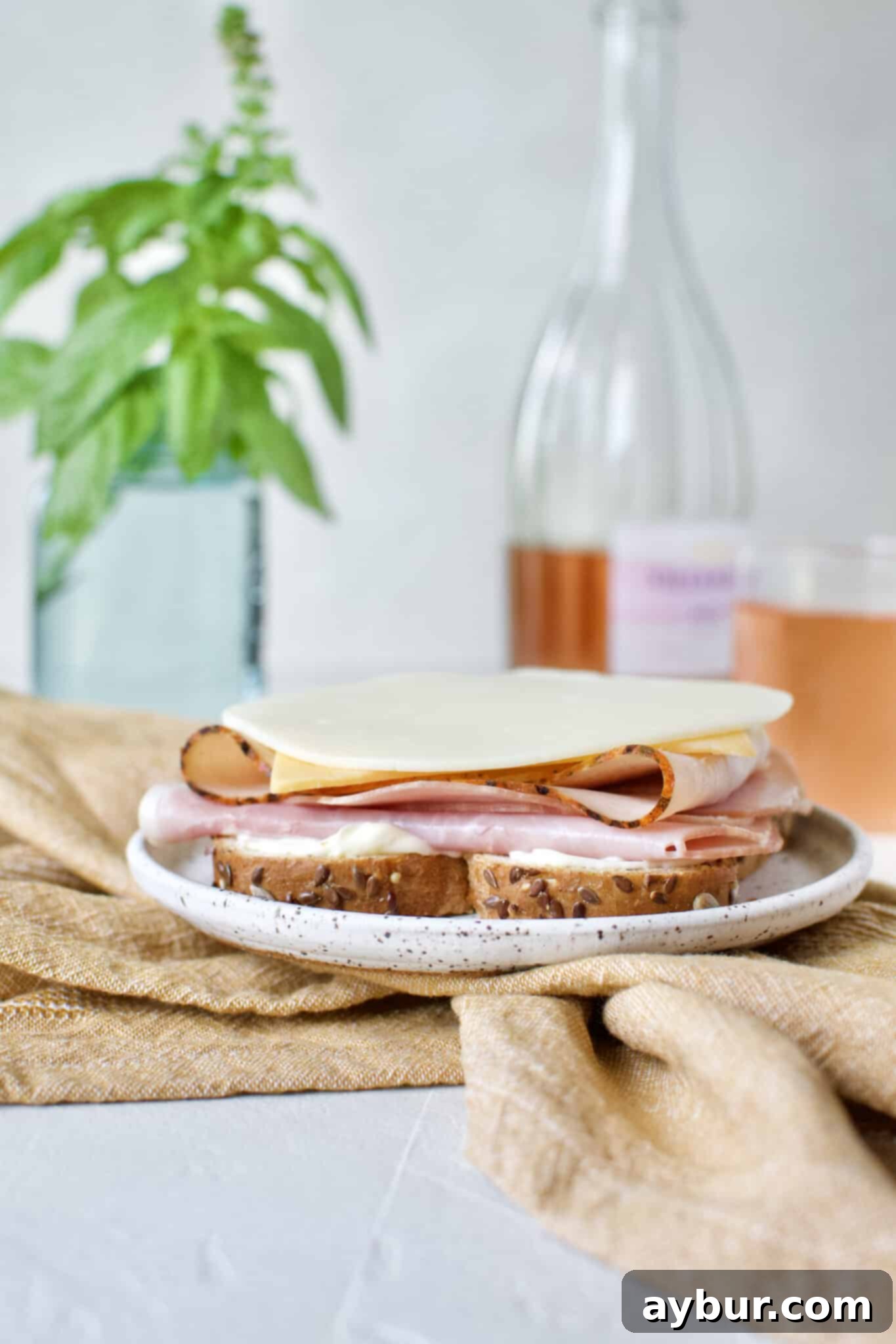 Adding a slice of smooth provolone cheese to the Club Sandwich, complementing the cheddar and deli meats.