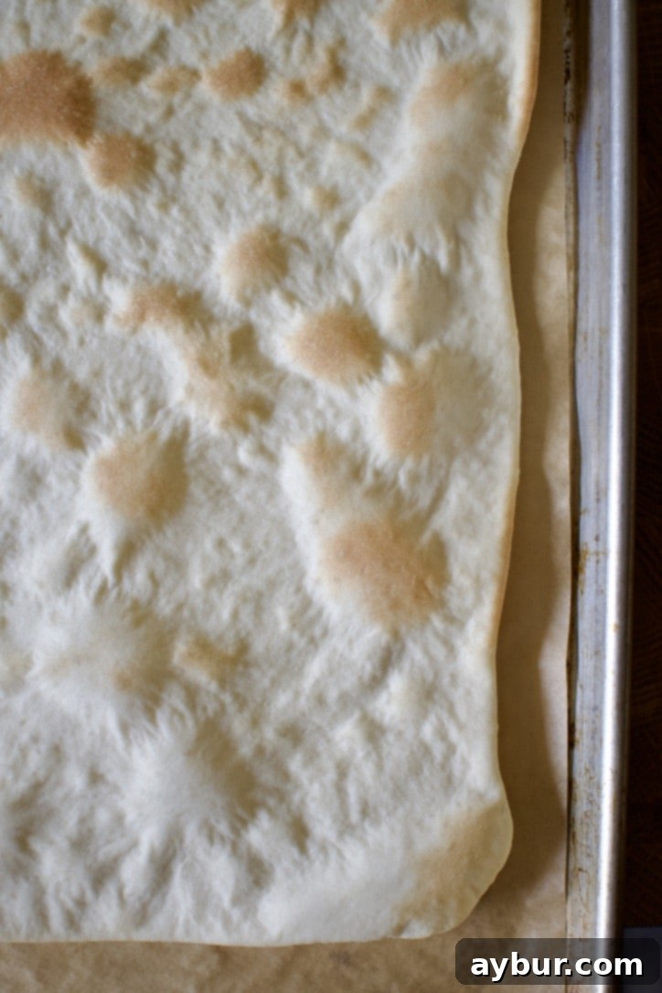 Creamy Garlic White Pizza 4 Pre-baked thin-crust pizza dough, golden and crispy, ready for toppings.