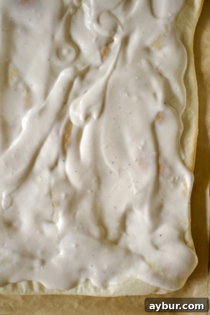 Cooked, Thin-Crust Pizza Dough Recipe, topped with alfredo sauce.