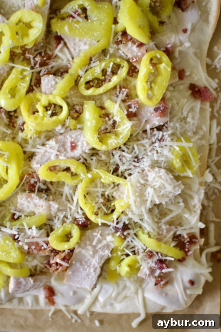 Creamy Garlic White Pizza 10 The final topping layer for white pizza: sauce, mozzarella, chicken, bacon, banana peppers, and grated Parmesan cheese.