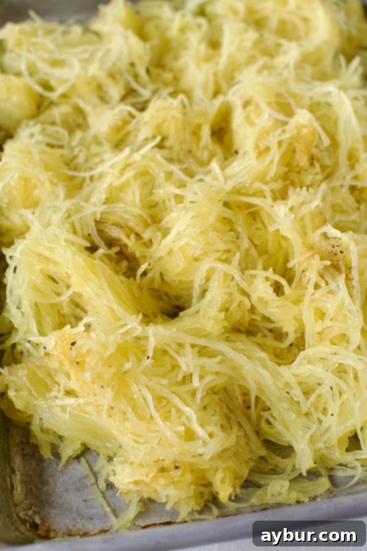 Freshly roasted spaghetti squash, carefully scraped from its skin into delicate, spaghetti-like strands, ready to be served.